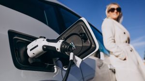 Woman charging electro car by her house